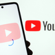 Pictured is the YouTube logo and a smartphone.